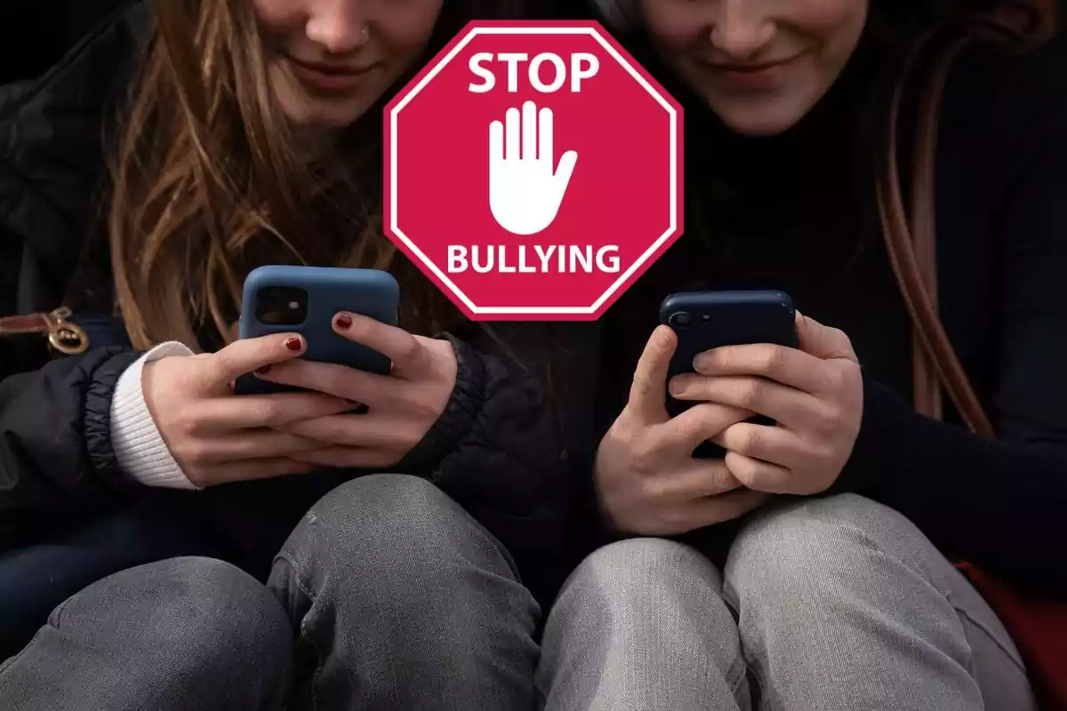 Nenes amb mòbil i un cartell de 'Stop Bullying'