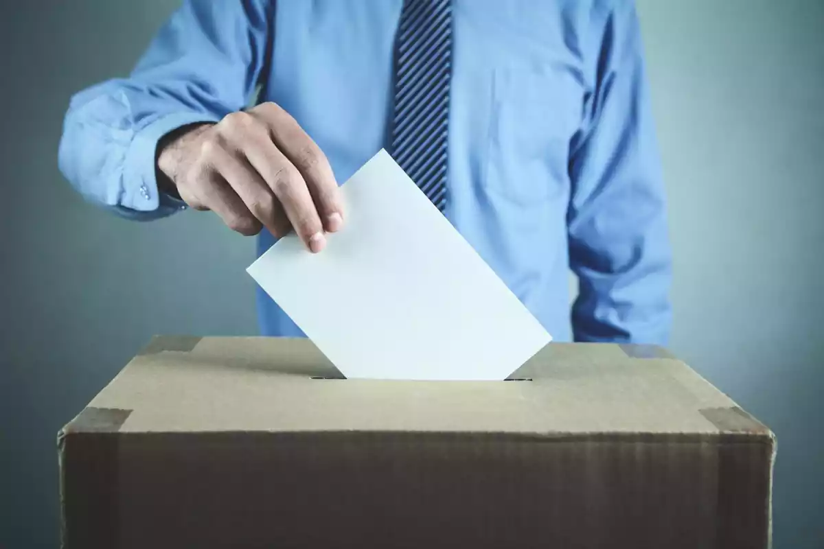 Un home posa el vot en una urna