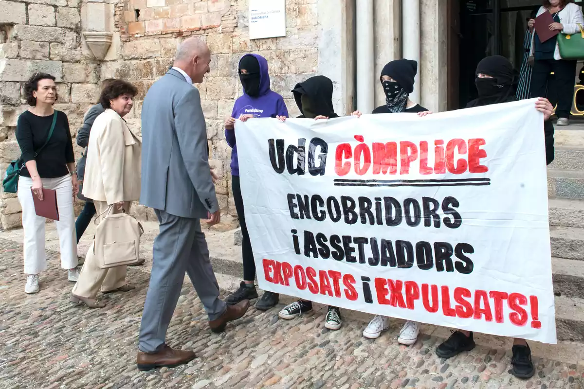 Diversos estudiants protesten davant de la presència del rector de la Universitat de Girona (UdG), Quim Salvi, a l'entrada de l'Aula Magna de la Universitat, el 13 d'octubre del 2022, a Girona