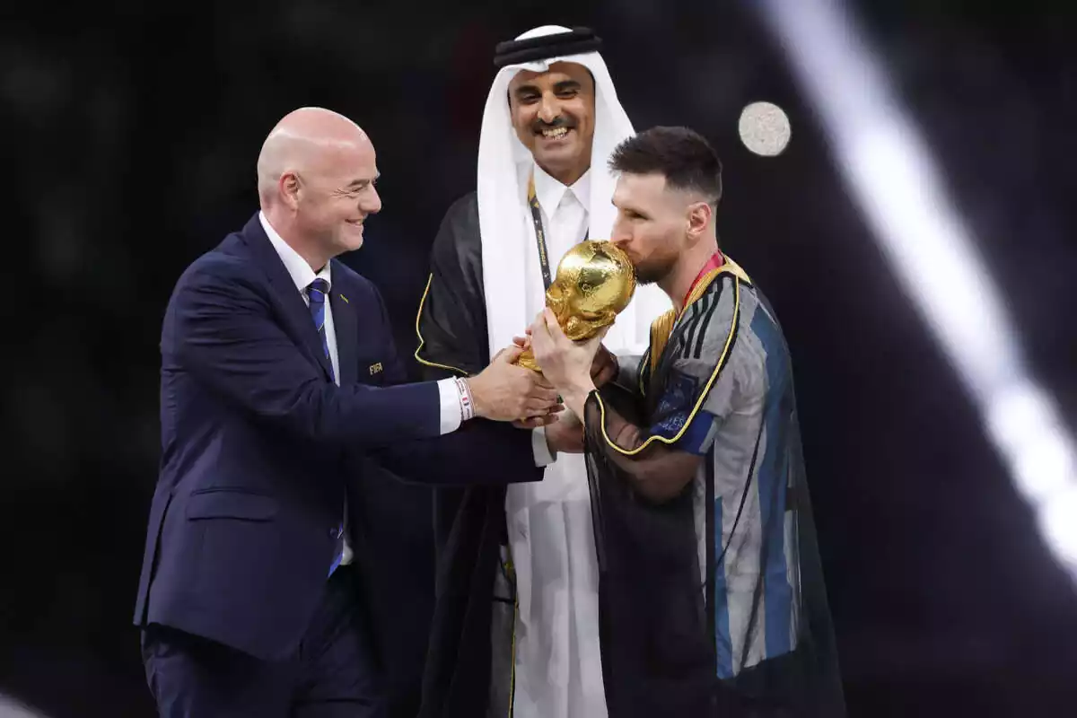 El xeic Tamim ben Hamad Al Thani somriu i mira com Leo Messi fa un petó a la Copa del Món, a mans del president de la FIFA, Gianni Infantino