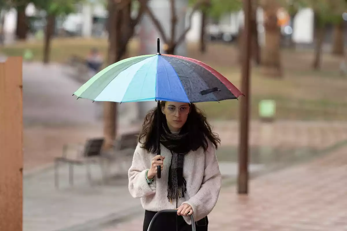 Una noia camina amb un paraigua a Barcelona