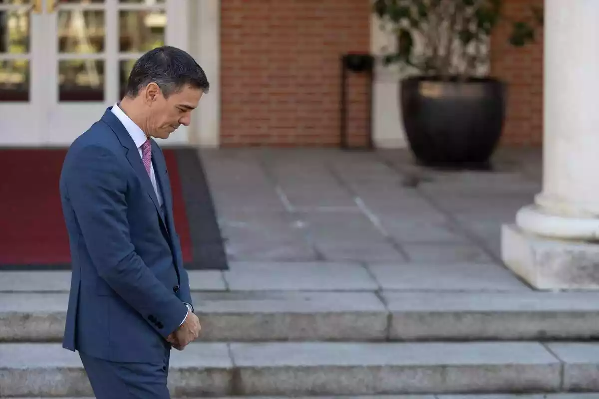 El president del Govern, Pedro Sánchez, mira cap a terra amb les mans juntes