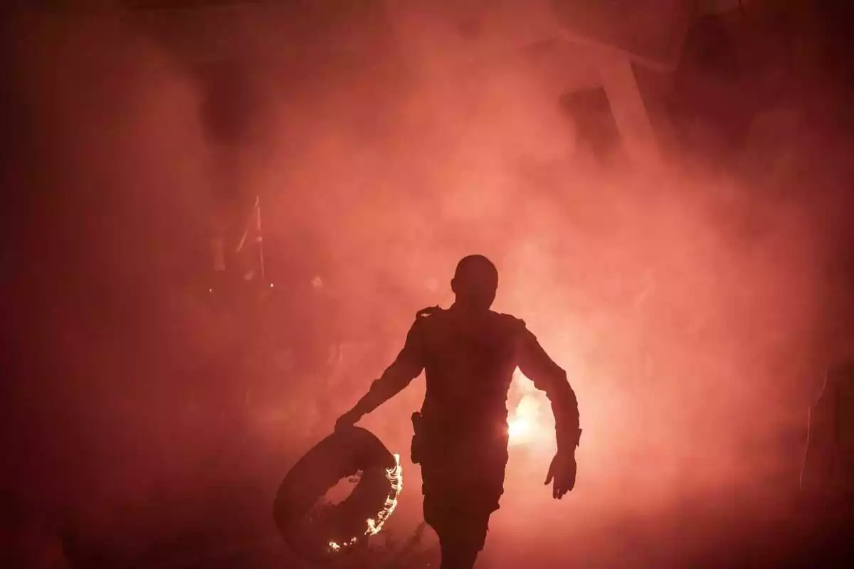 Un policia porta un nivell en flames durant una protesta a Jerusalem contra el govern religiós de dreta del primer ministre Benjamin Netanyahu