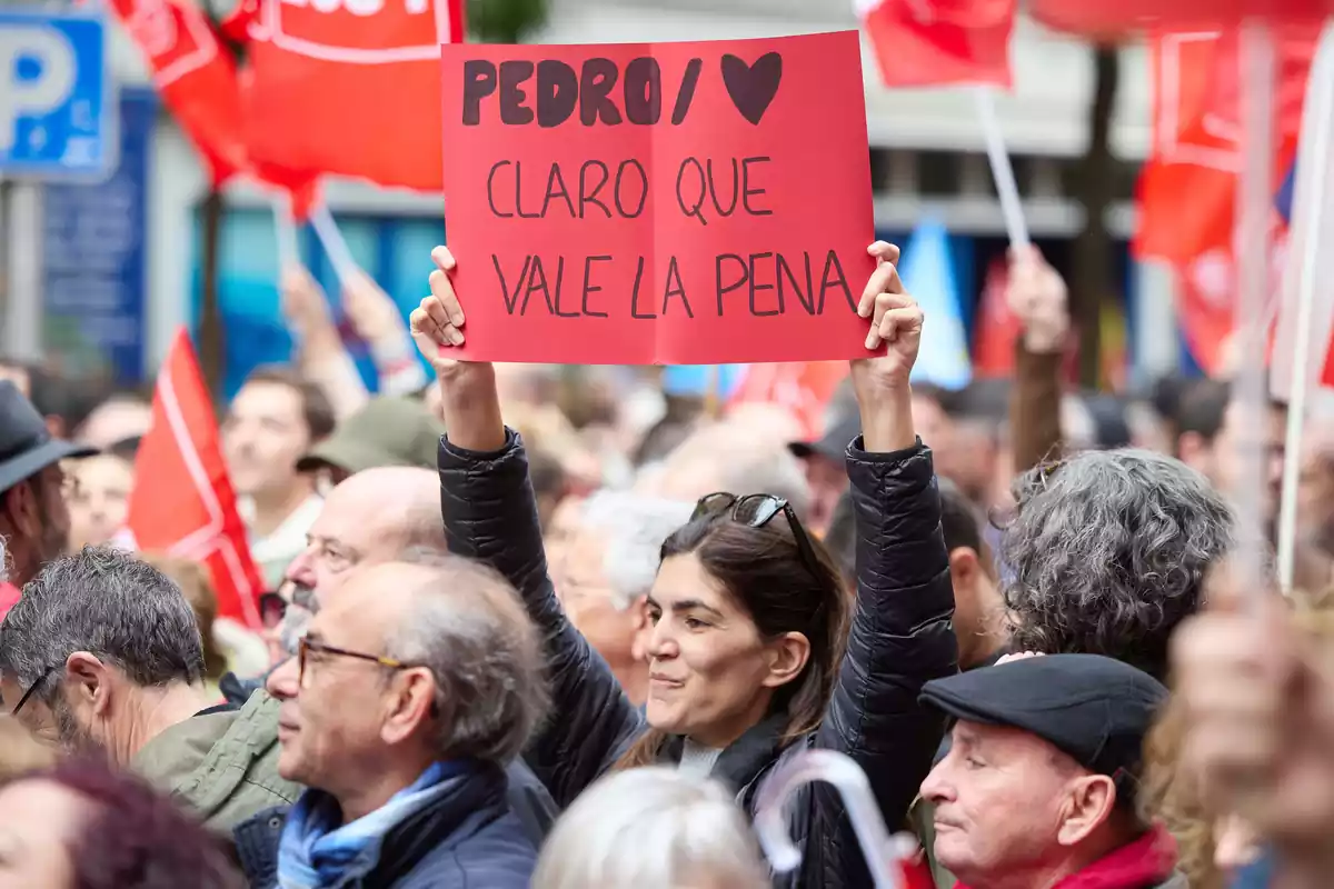 Una dona subjecta un cartell durant una concentració al carrer de Ferraz en suport al president del Govern, Pedro Sánchez, a la seu del PSOE