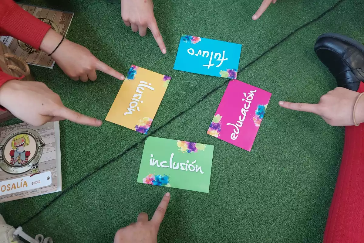 Infants indicant les cartes d'inclusió, il·lusió, futur i educació