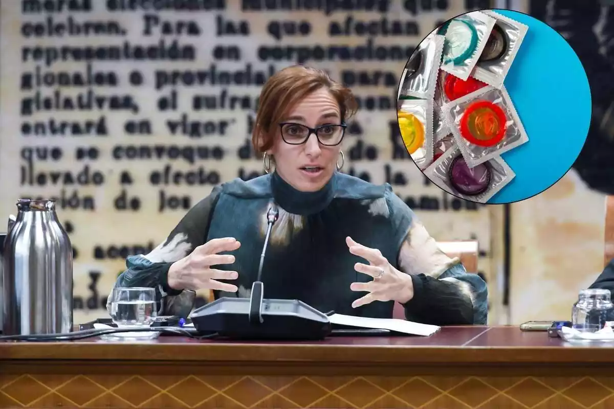 La ministra de Sanitat Mónica García juntament amb una imatge de preservatius