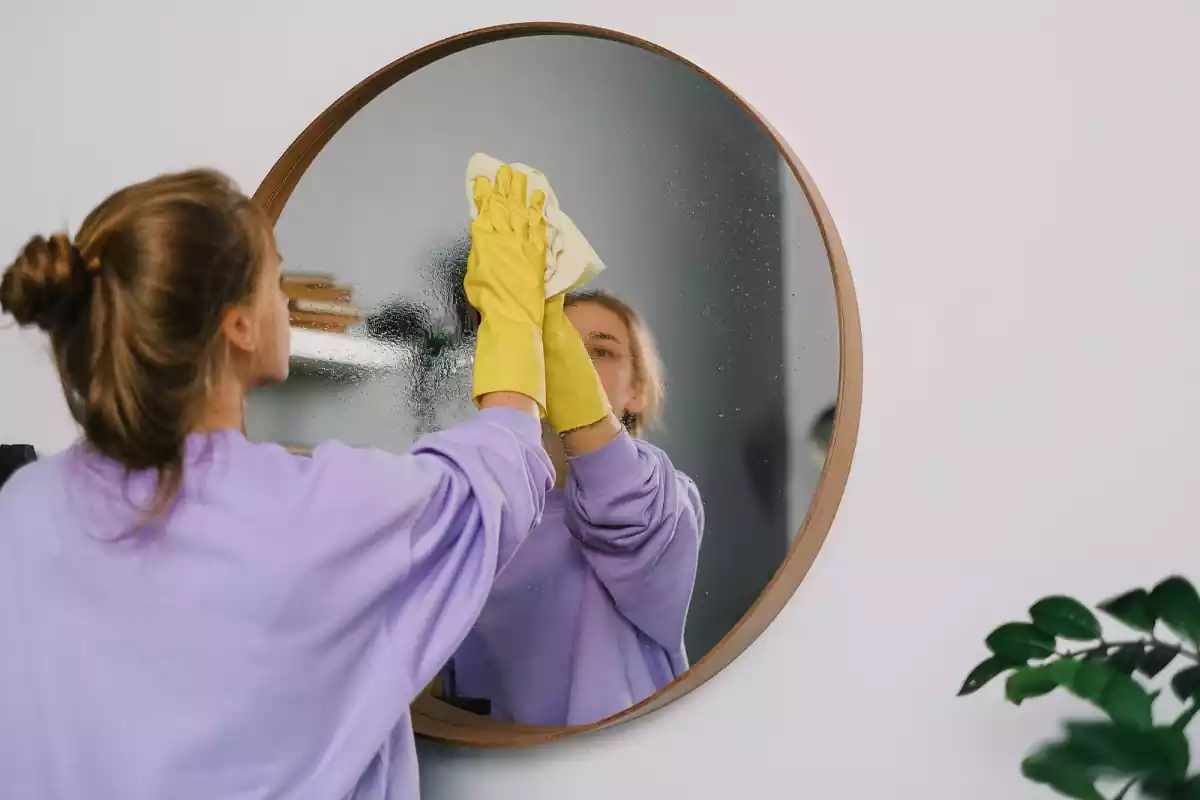 Una dona netejant un mirall