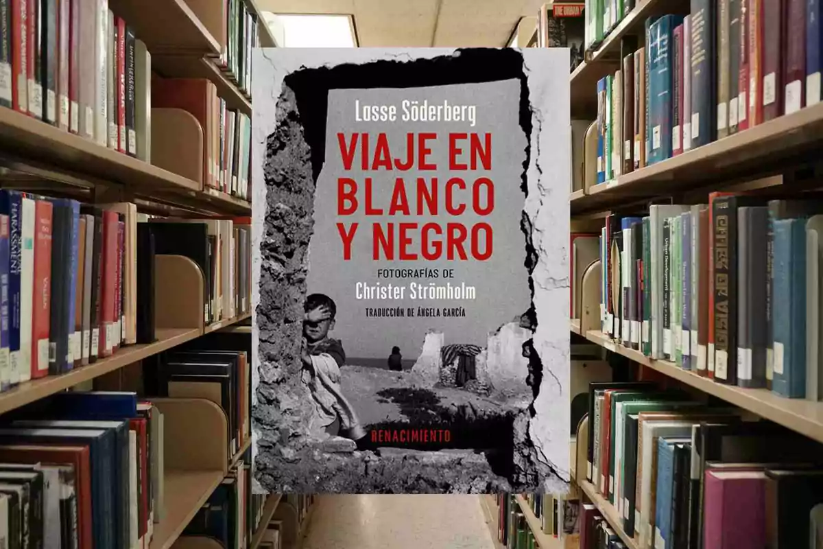 La imatge mostra un llibre titulat "Viatge en blanc i negre" de Lasse Söderberg, amb fotografies de Christer Strömholm i traducció d'Àngela García, col·locat a un prestatge d'una biblioteca.