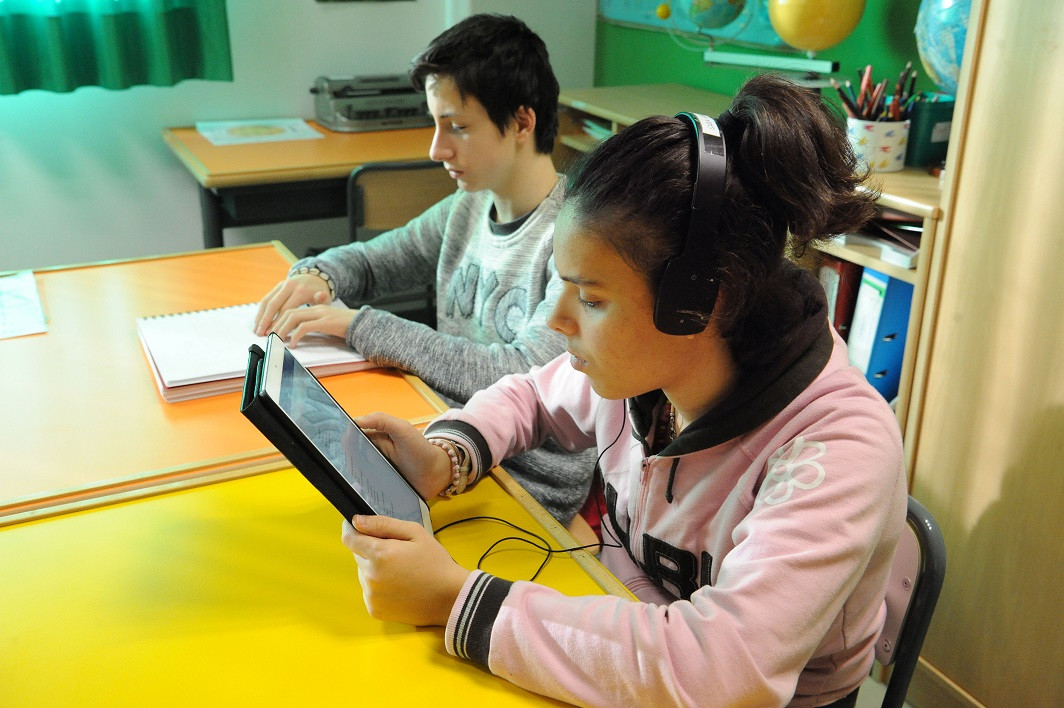 Dos chicos leyendo en diferentes formatos