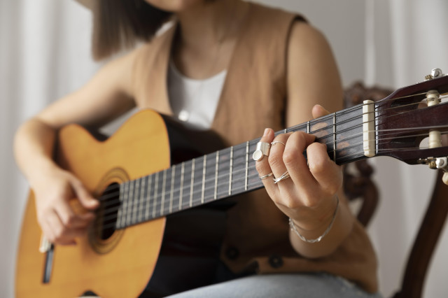 Youngwomanplayingguitarindoors