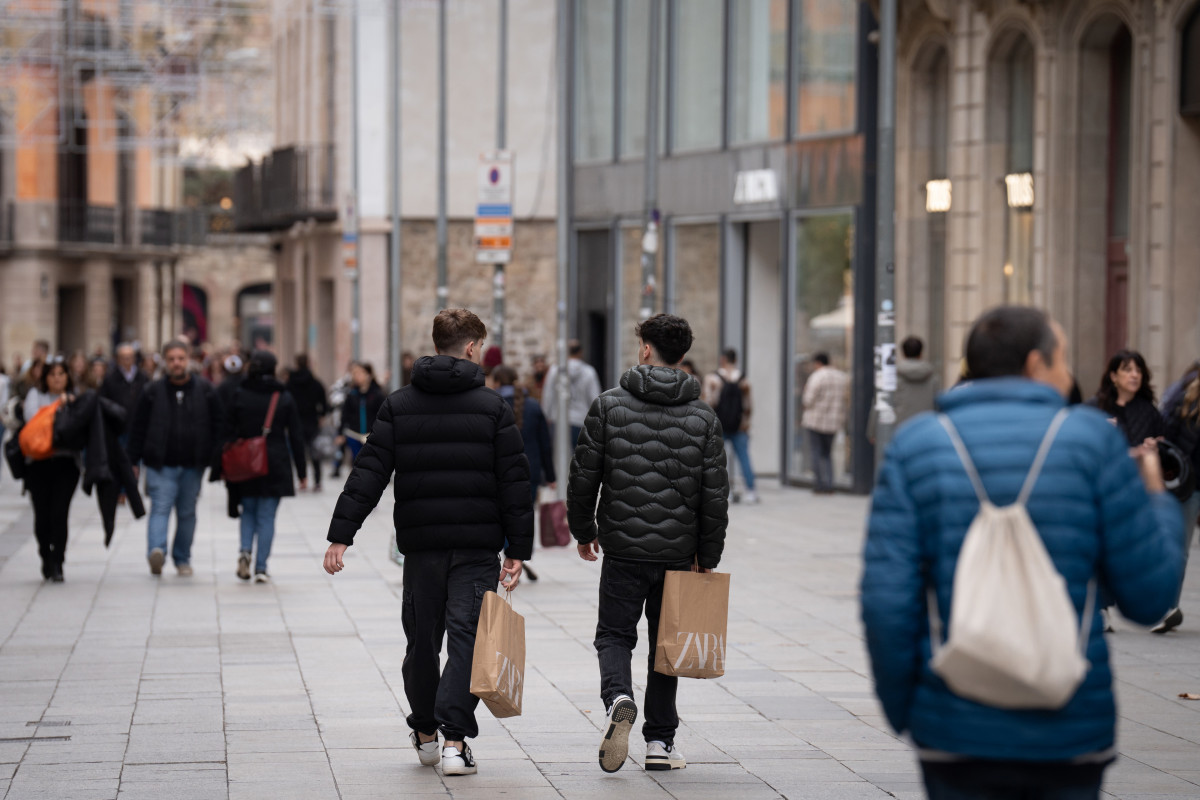 Archivo - Jóvenes sujetan bolsas con compras