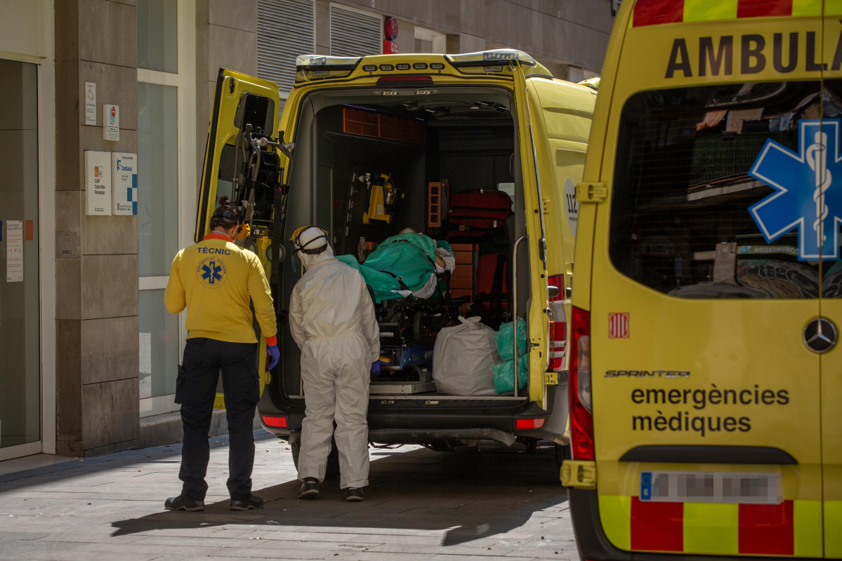 Dos sanitaris a la porta d'una ambulància en la qual hi ha un pacient contagiat amb coronavirus al Centre d'Emergències d'Atenció Primària Pere Camps al Raval, a Barcelona / Catalunya (Esp