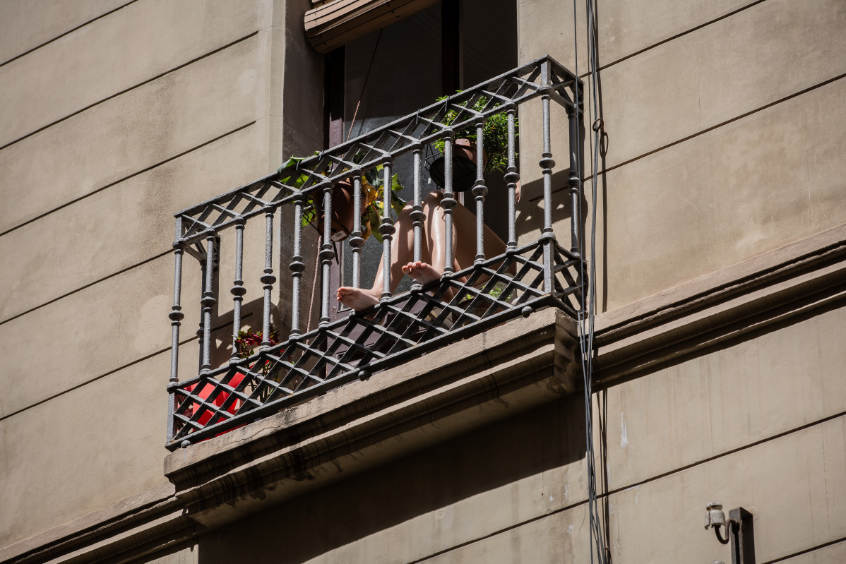 Una persona pren el sol en el seu balcó durant el tercer dia de desconfinamiento d'adults i durant la fase 0 de la desescalada en què es permet l'obertura de certs establiments, a Barcelona / Catalunya (Espanya) a 4 de maig de 2020.