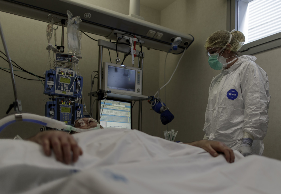 Personal sanitari totalment protegit atén un pacient ingressat a la Unitat de Cures Intensives de l'Hospital Infanta Sofia a Sant Sebastià dels Reis (Madrid).