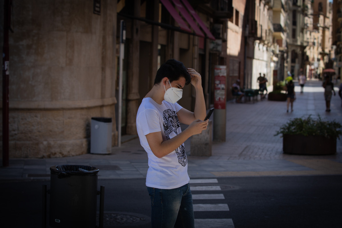 Un jove protegit amb mascareta camina per un carrer de centre de Lleida, capital de la comarca de Segrià, a Lleida, Catalunya (España), a 6 de juliol de 2020.