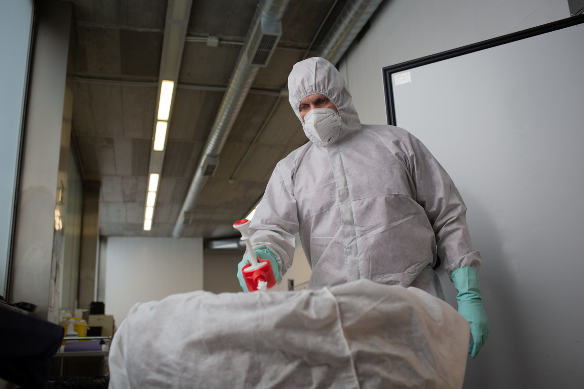 Un operari de l'Crematori de Girona desinfecta el cos d'una persona morta amb Covid-19 i el su Taut, Abans d'introduir-li al forn crematori. A Girona, Catalunya, (Espanya), a 6 de maig de 2020 (arxiu).