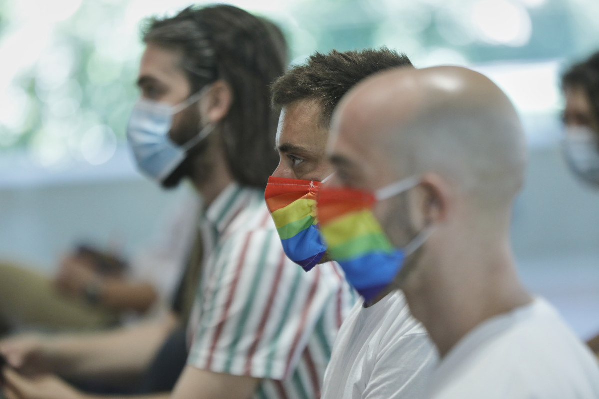 Dos homes es protegeixen amb mascaretes amb la bandera LGTB durant la seva participació en l'acte institucional amb motiu de l'Orgull 2020, a Madrid (Espanya), a 29 de juny de 2020.