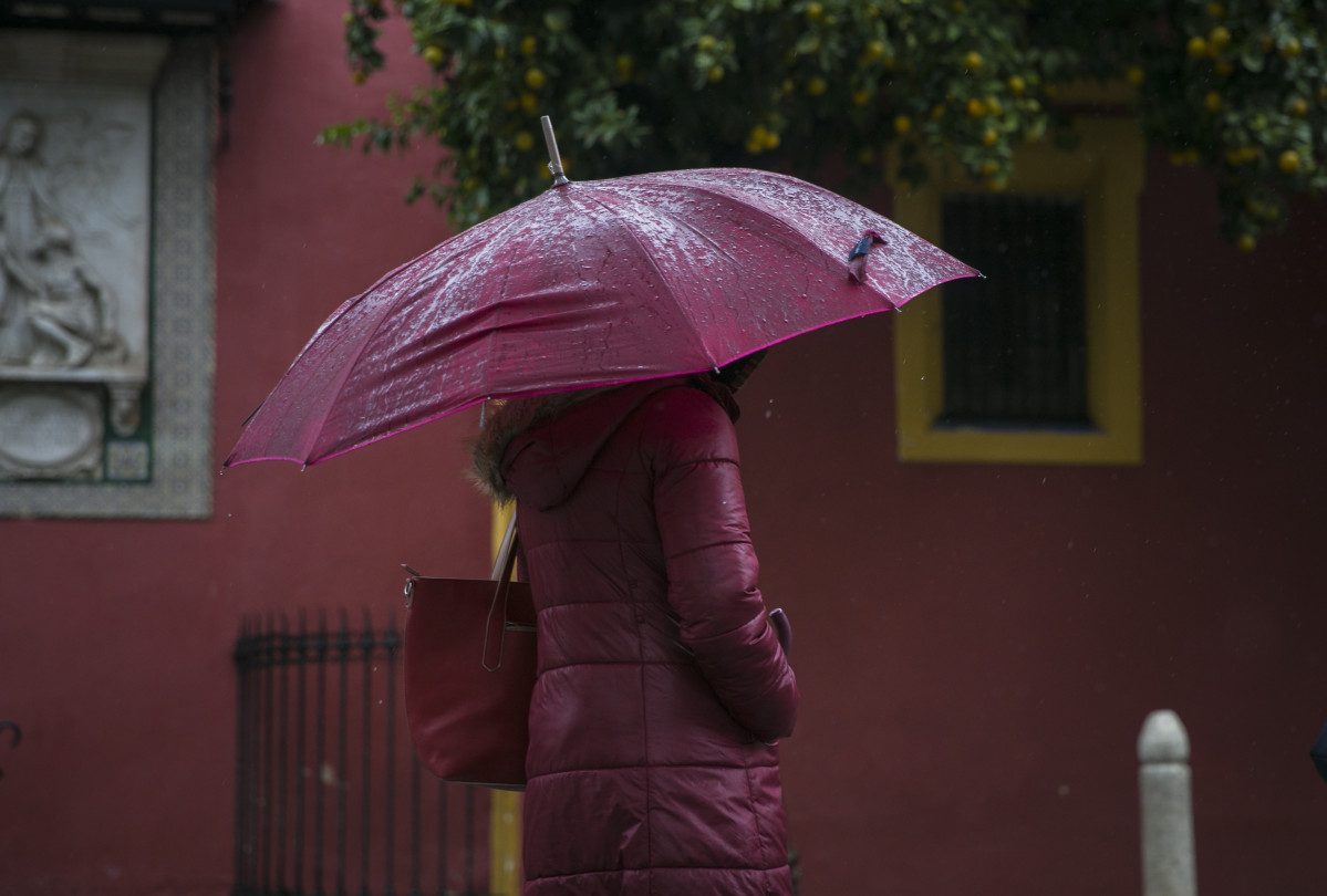 Una dona és protegeix de la pluja a la plaça de Sant Llorenç. Sevilla, 22 de novembre de l'2019.