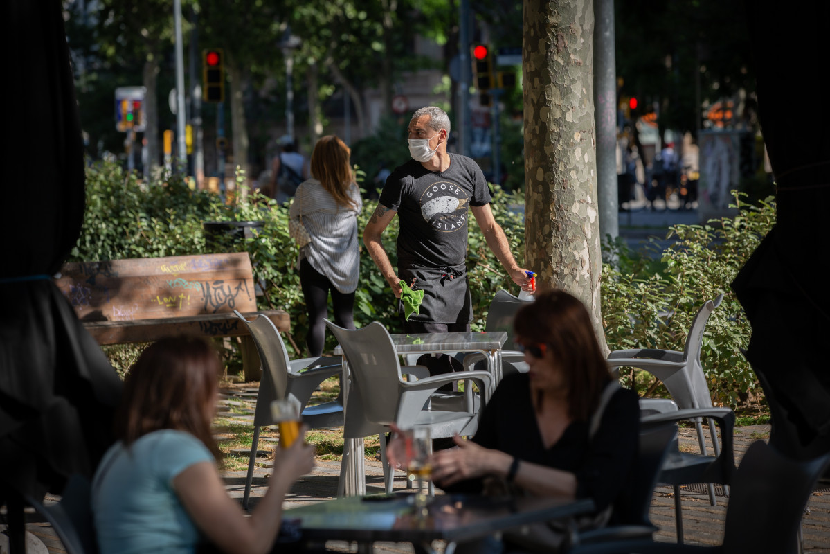 Diverses persones gaudeixen a la terrassa d'un bar durant el segon dia de la reobertura a el públic de les terrasses a l'aire lliure dels establiments d'hostaleria i restauració limitant-se