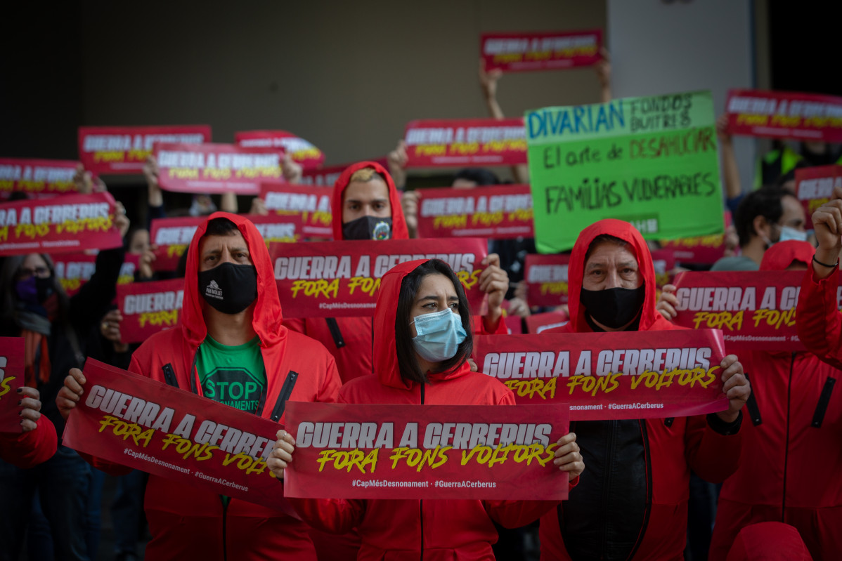 Al voltant de 50 persones vestides de vermell es concentren davant de la seu de Faig Real State, immobiliària de el fons d'inversió Cerberus, a Barcelona, Catalunya (Espanya), a 30 de novembre de 2020.