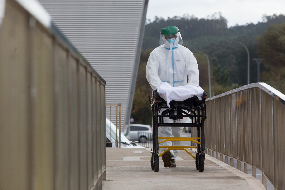 Un treballador sanitari totalment protegit trasllada una llitera en els voltants de la residència d'avis de Sant Cibrao on s'ha originat un brot de Covid-19, a Sant Cibrao, Lugo, Galícia, (Espanya), a 9 de novembre de 2020. En el centre la