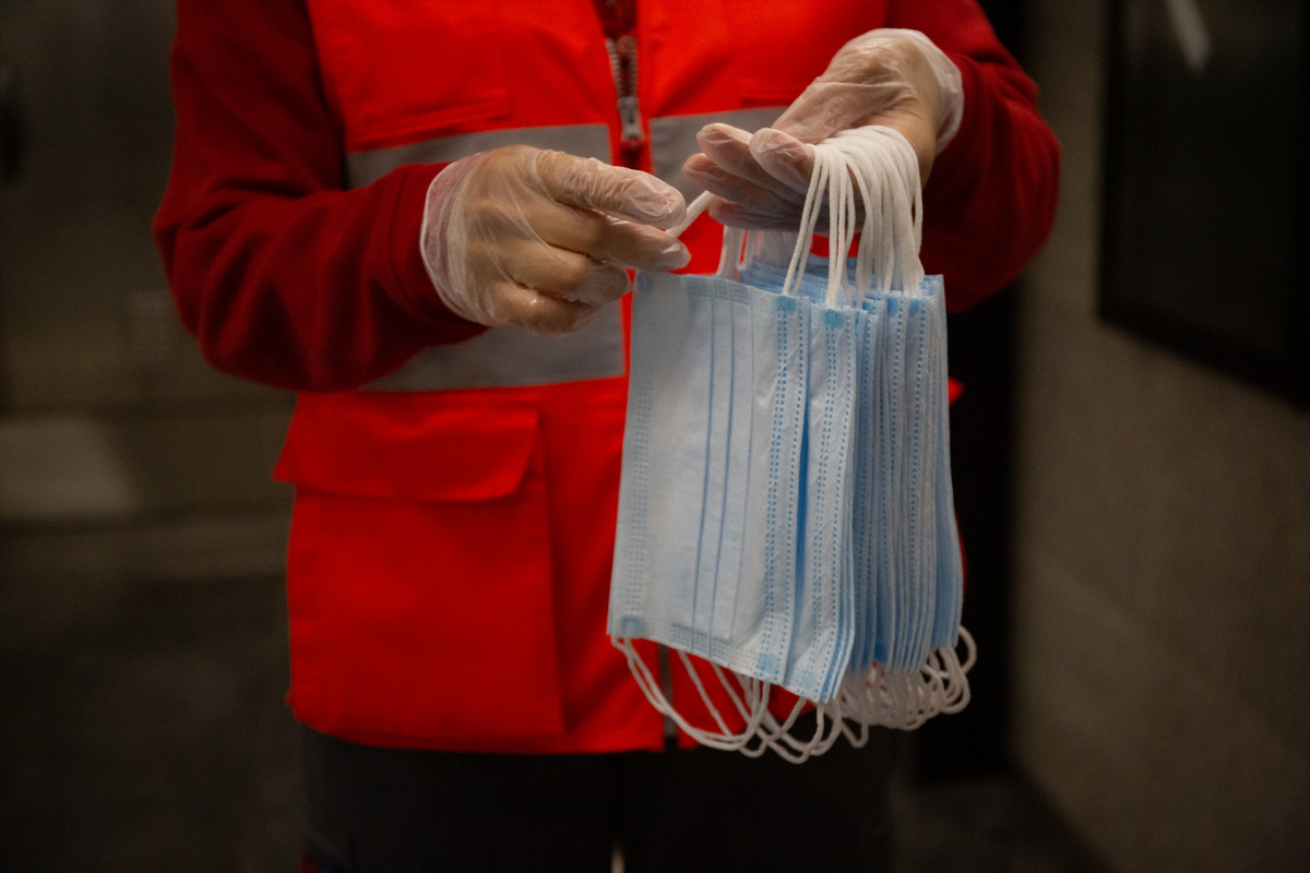 Arxiu - Una voluntària de Creu Roja es prepara per lliurar mascaretes a l'estació catalana de Diagonal el dia en què es reactiva l'activitat laboral no essencial a Catalunya