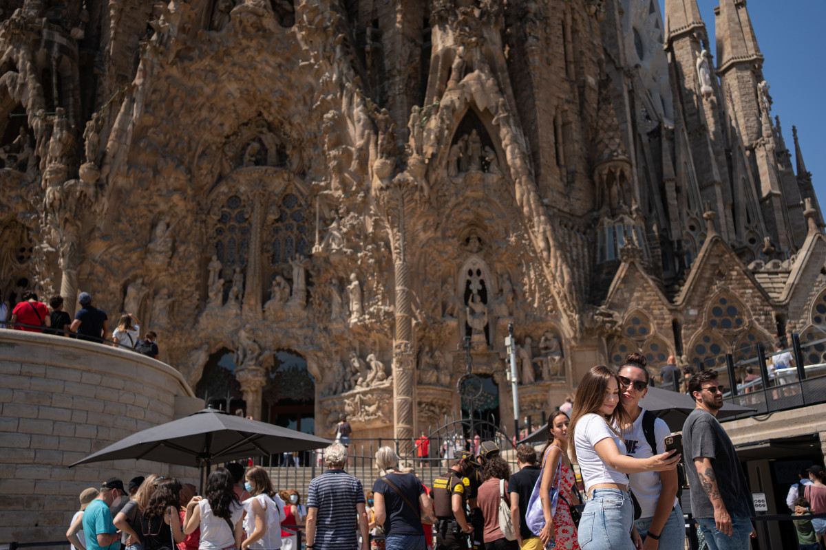 Arxiu - Dues noies es fan un 'selfie' davant de la Sagrada Família, durant el primer dia en el qual no és obligat l'ús de la màscara en exteriors des de l'inici de la pandèmia, 26 de juny de 2021, a Barcelona, Catalunya (España). El 30 de