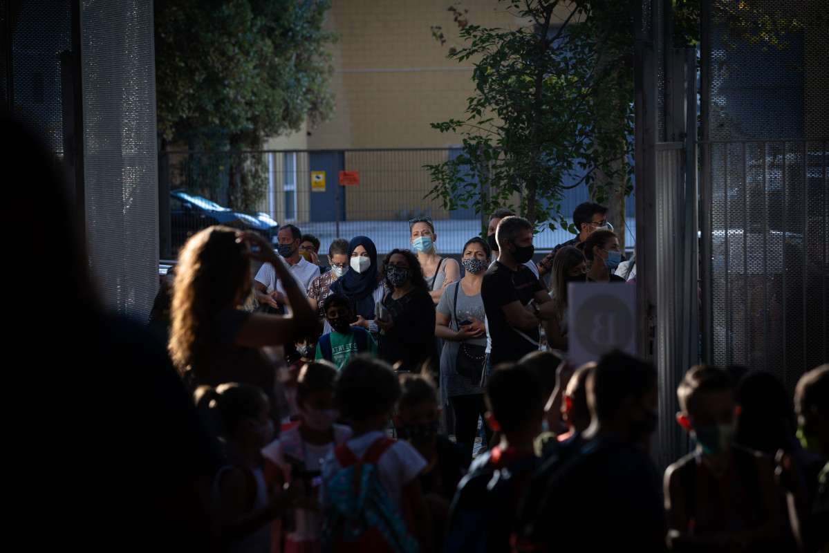 Archivo - Padres y alumnos esperan a las puertas de un colegio durante el primer día del curso escolar 2020-2021, en Barcelona