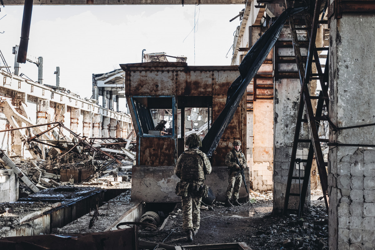 Dos soldats, de l'exèrcit ucraïnès, caminen per una antiga fàbrica destruïda per la guerra a la línia del front, a 19 de febrer de 2022, a Avdiivka, Oblast de Donetsk (Ucraïna).